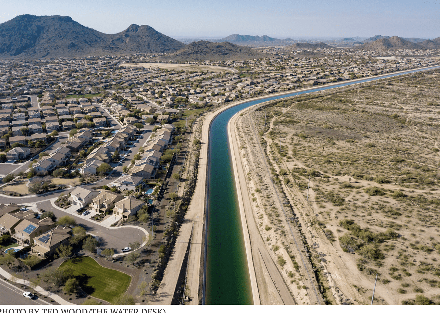 Aerial view of canal between suburb and desert
