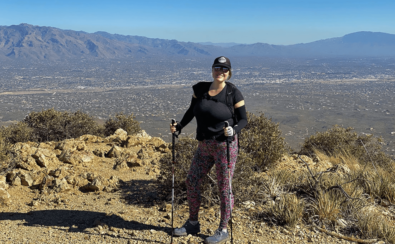 Hiker with trekking poles on mountain vista