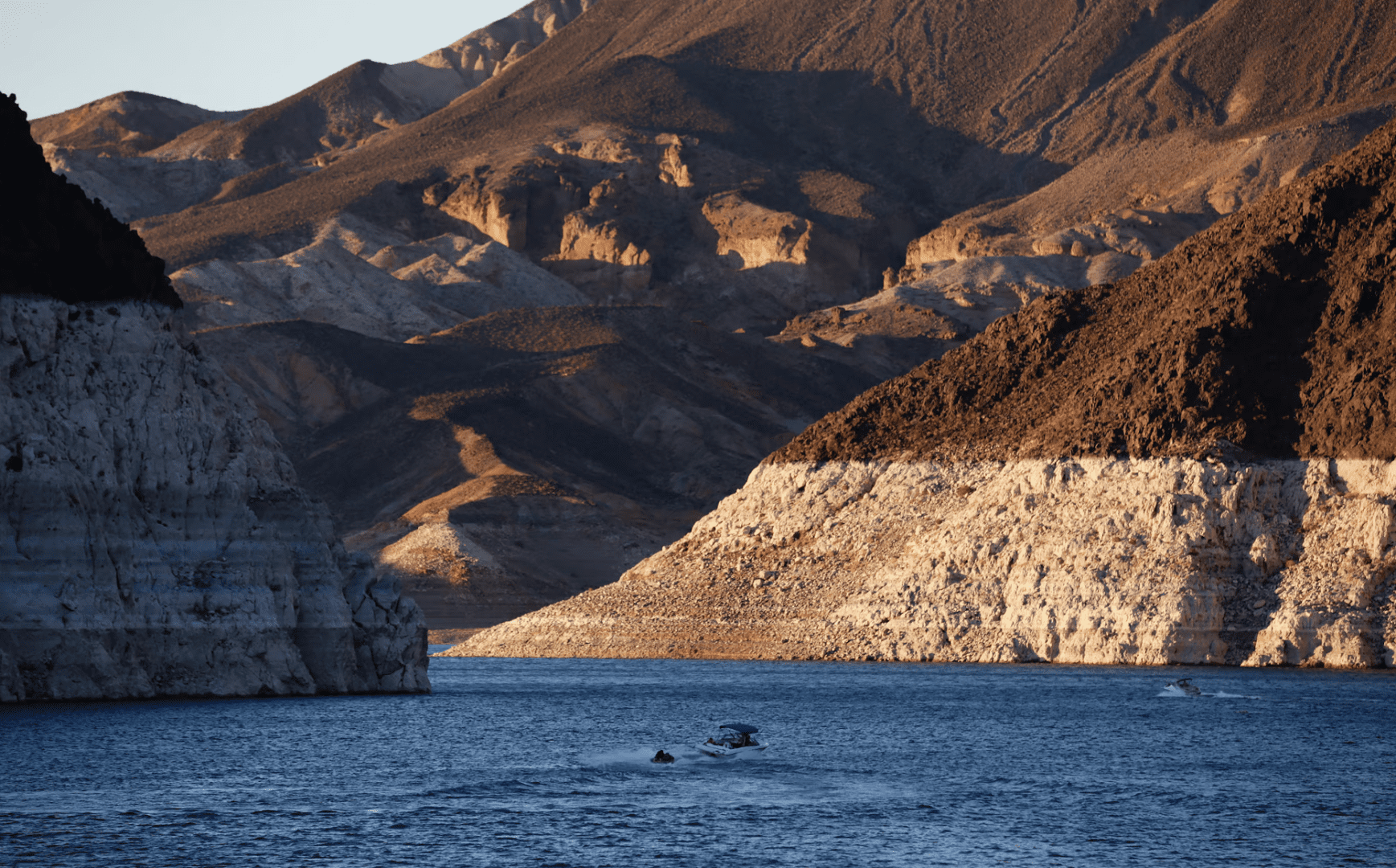 Small boat near layered rocky shoreline