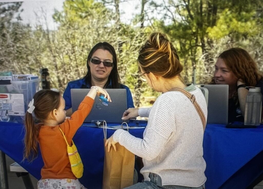 Child and woman at outdoor registration table